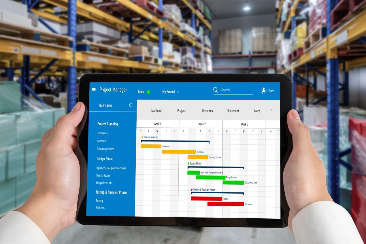 Ein Mitarbeiter nutzt eine Produktionsplanung Software auf einem Tablet, um Produktionsprozesse und Lagerbestände mit einem digitalen Gantt-Diagramm zu koordinieren.